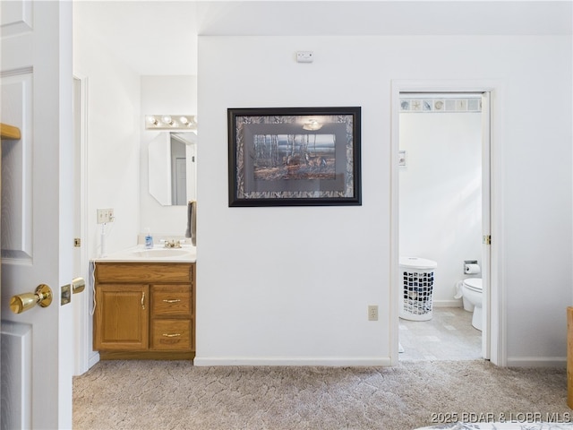 bathroom with toilet, vanity, and baseboards