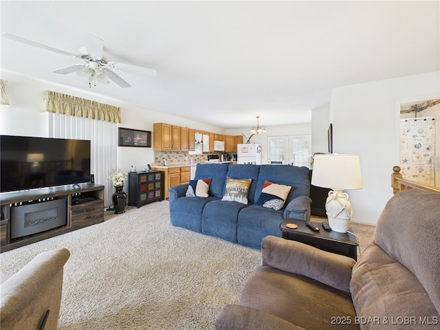 living room featuring carpet, a chandelier, and ceiling fan