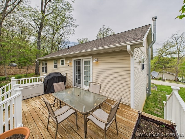 wooden terrace with outdoor dining space and area for grilling
