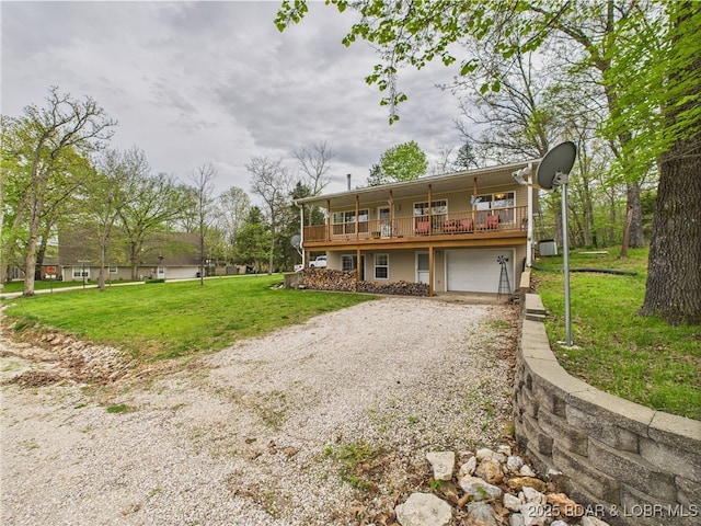 view of front of house featuring gravel driveway, a front yard, an attached garage, and a wooden deck