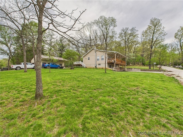 view of green lawn featuring a wooden deck