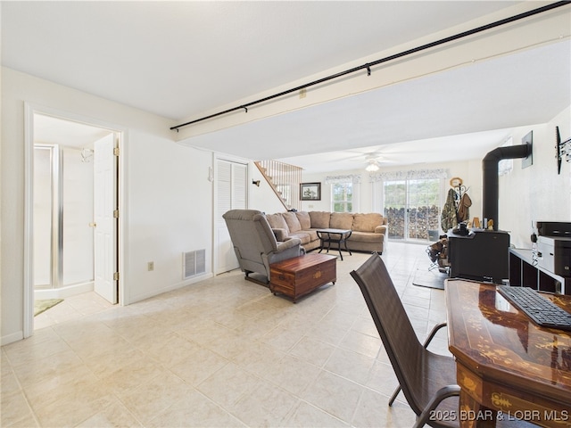 dining room featuring a ceiling fan, light tile patterned floors, baseboards, and stairs