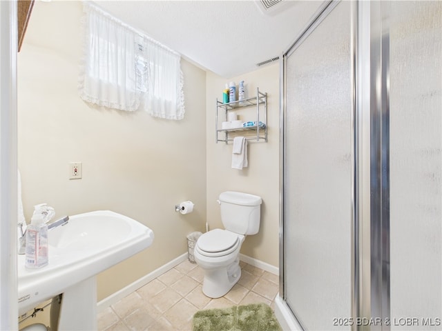 full bath with a stall shower, toilet, tile patterned flooring, and baseboards