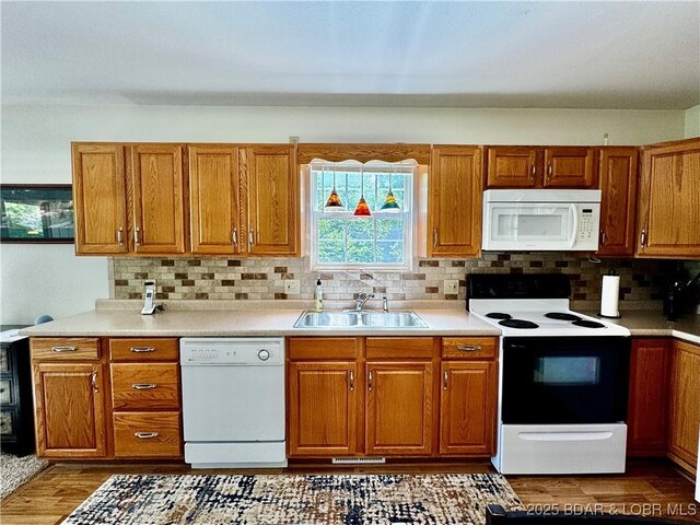 34 Glenmeadows Ct, Linn Creek, MO 65052 - kitchen featuring white appliances, brown cabinets, backsplash, wood finished floors, and light countertops