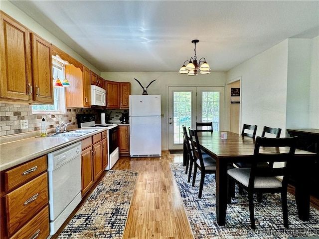 34 Glenmeadows Ct, Linn Creek, MO 65052 - kitchen with white appliances, a chandelier, light wood-type flooring, light countertops, and brown cabinetry