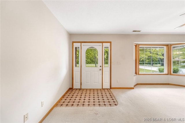 foyer entrance featuring carpet flooring and baseboards
