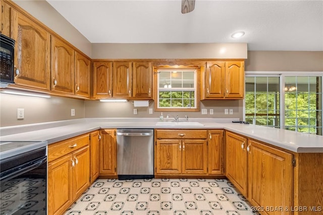 kitchen featuring stainless steel dishwasher, a sink, electric stove, light countertops, and a peninsula