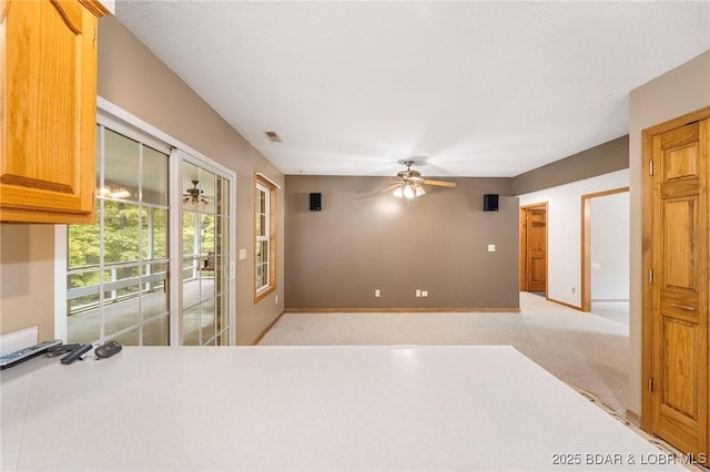 unfurnished bedroom with light carpet, access to exterior, and a ceiling fan