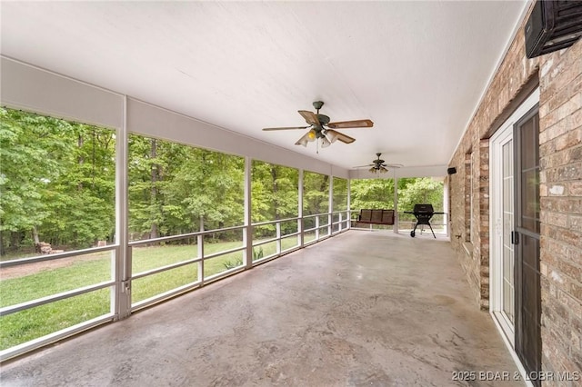 unfurnished sunroom with a ceiling fan