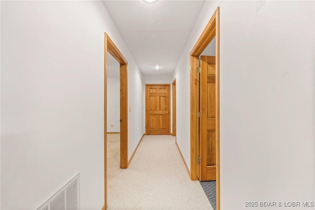 hall with light carpet and baseboards
