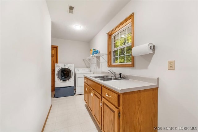 laundry room with washing machine and dryer, light floors, baseboards, and cabinet space