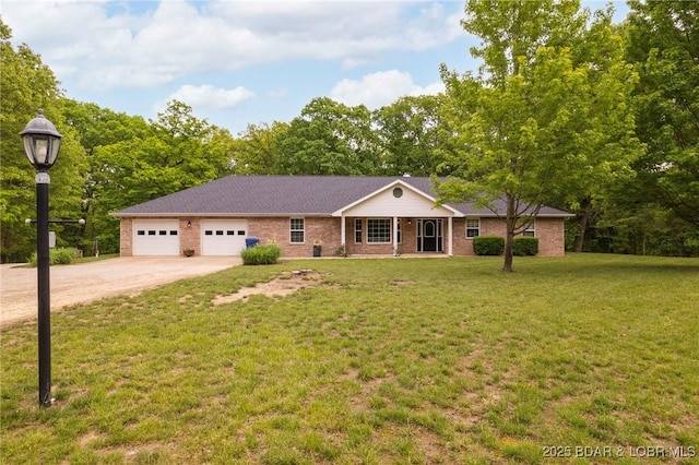 ranch-style house featuring driveway, a garage, brick siding, and a front yard