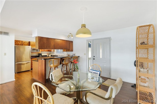 dining area featuring dark wood finished floors and baseboards
