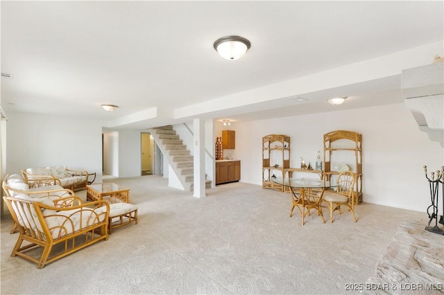 sitting room with stairs and carpet floors