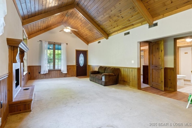 217 Westview Rd, Climax Springs, MO 65324 - unfurnished living room featuring wainscoting, a ceiling fan, carpet, wood ceiling, and a fireplace with raised hearth