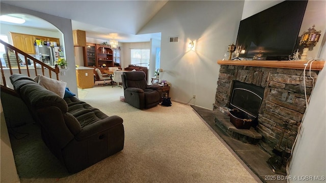 living area with carpet floors, lofted ceiling, and a fireplace