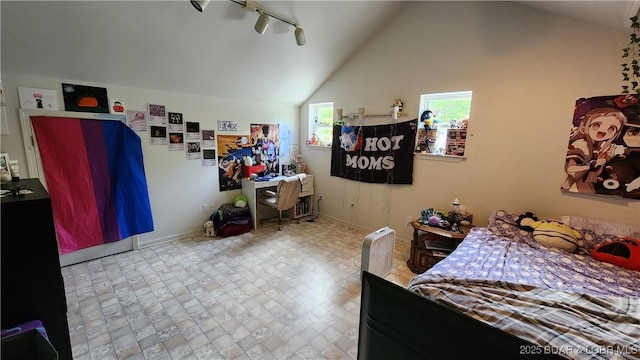 bedroom featuring baseboards, vaulted ceiling, and rail lighting