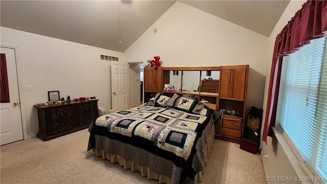 bedroom with light colored carpet, multiple windows, and high vaulted ceiling