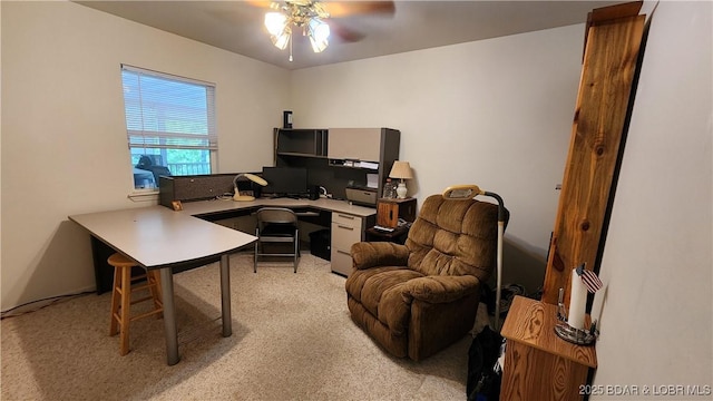 home office featuring light carpet and a ceiling fan