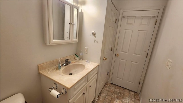 half bathroom featuring vanity and toilet