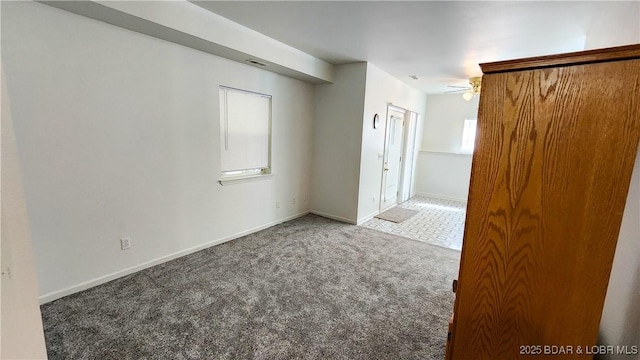unfurnished room with carpet and baseboards