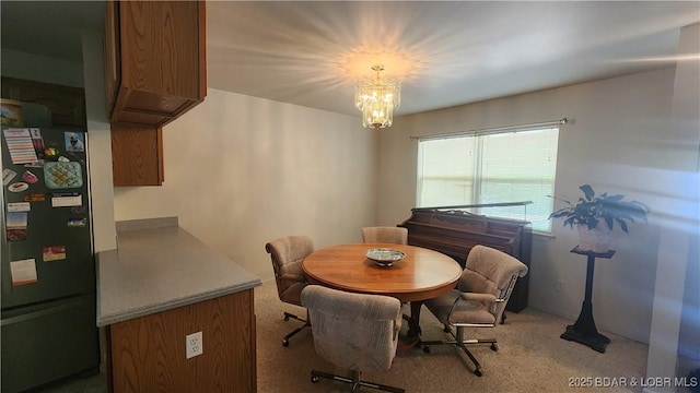 dining space with light colored carpet and a chandelier