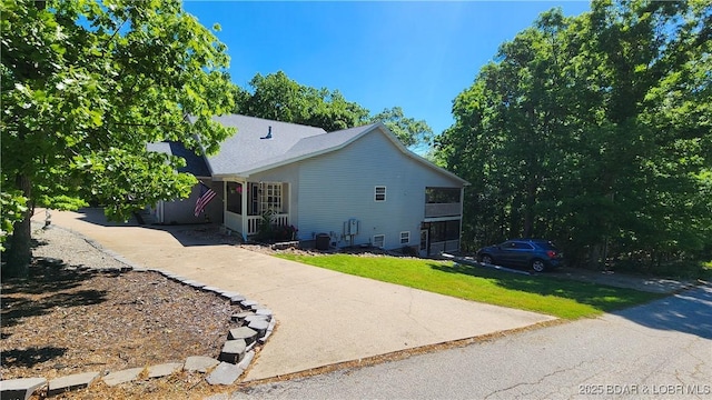 view of side of home featuring a lawn and central AC