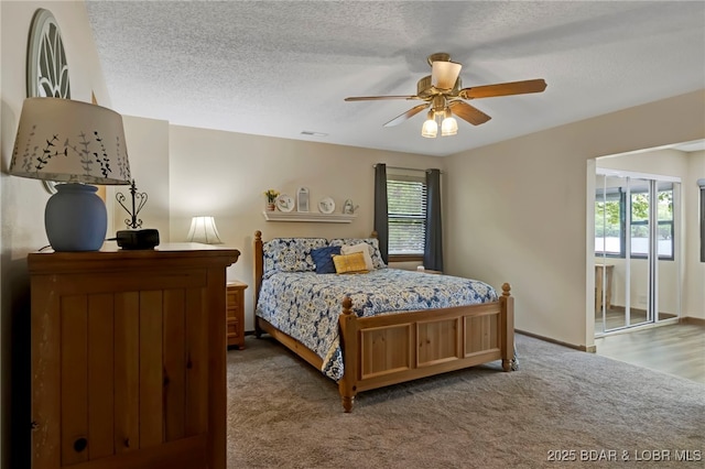 bedroom featuring carpet flooring, a ceiling fan, and a textured ceiling