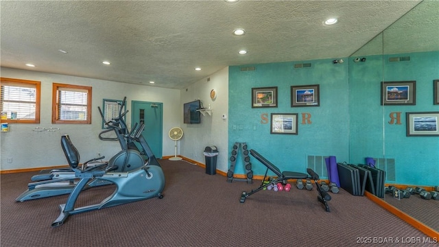 exercise area with a textured ceiling, baseboards, and recessed lighting