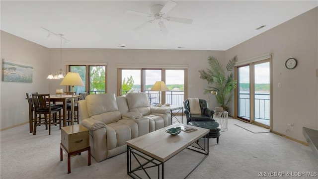 living room featuring light colored carpet, baseboards, and healthy amount of natural light