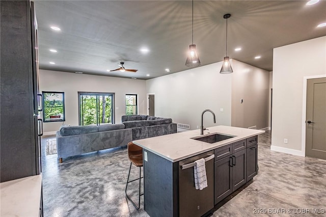 kitchen featuring a sink, stainless steel dishwasher, concrete flooring, recessed lighting, and a kitchen breakfast bar