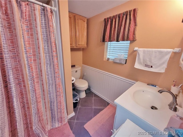 bathroom featuring tile patterned flooring, a wainscoted wall, toilet, curtained shower, and vanity