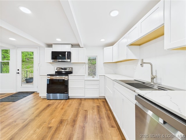 27294 Marina Ln, Barnett, MO 65011 - kitchen with appliances with stainless steel finishes, a sink, white cabinets, light wood-style flooring, and light stone counters