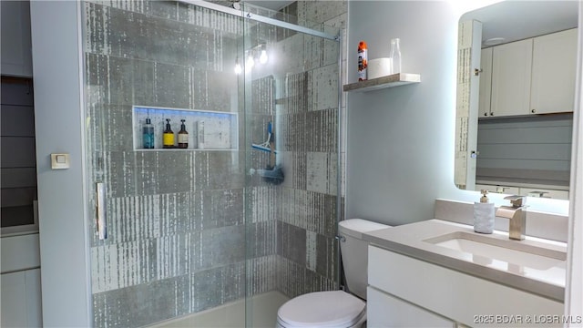 full bathroom with toilet, a shower stall, and vanity