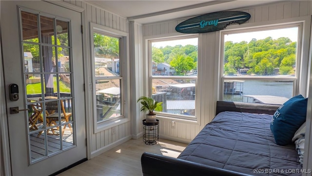 bedroom with wood-type flooring and wood walls