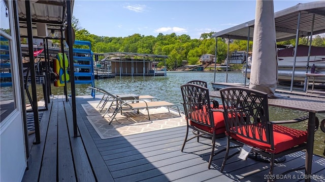 dock with a water view, boat lift, and a forest view