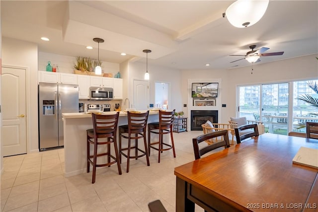 85 Monarch Cove Ln Unit 2C, Lake Ozark, MO 65049 - dining area with ceiling fan, a glass covered fireplace, recessed lighting, and light tile patterned flooring