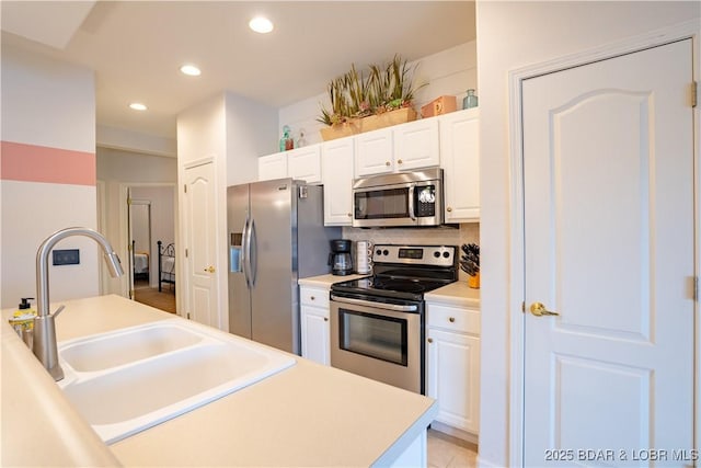 85 Monarch Cove Ln Unit 2C, Lake Ozark, MO 65049 - kitchen featuring appliances with stainless steel finishes, a sink, white cabinets, recessed lighting, and backsplash