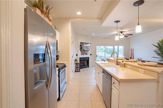 85 Monarch Cove Ln Unit 2C, Lake Ozark, MO 65049 - kitchen featuring appliances with stainless steel finishes, light tile patterned floors, a glass covered fireplace, a ceiling fan, and pendant lighting