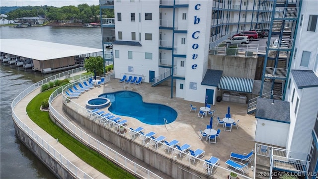 85 Monarch Cove Ln Unit 2C, Lake Ozark, MO 65049 - view of pool with a pool with connected hot tub, a water view, and fence