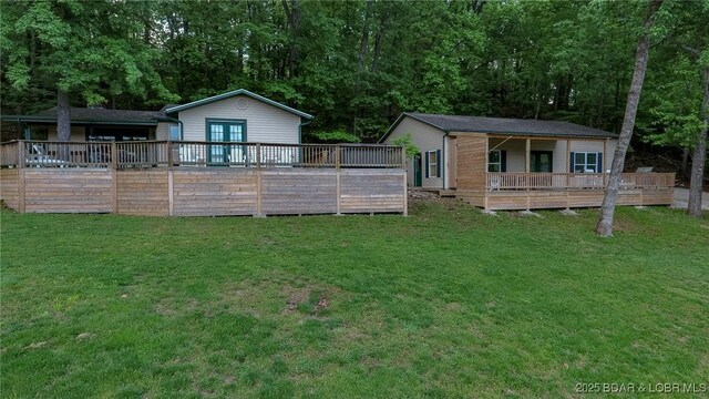 6076 Sioux Trl, Osage Beach, MO 65065 - back of house featuring a deck and a lawn