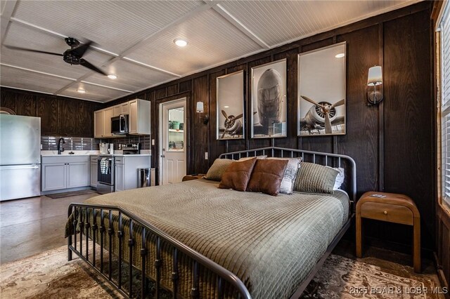 6076 Sioux Trl, Osage Beach, MO 65065 - bedroom with freestanding refrigerator, a sink, wooden walls, and recessed lighting