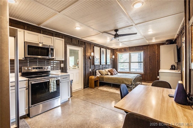 6076 Sioux Trl, Osage Beach, MO 65065 - kitchen with appliances with stainless steel finishes, wooden ceiling, light countertops, ceiling fan, and wooden walls