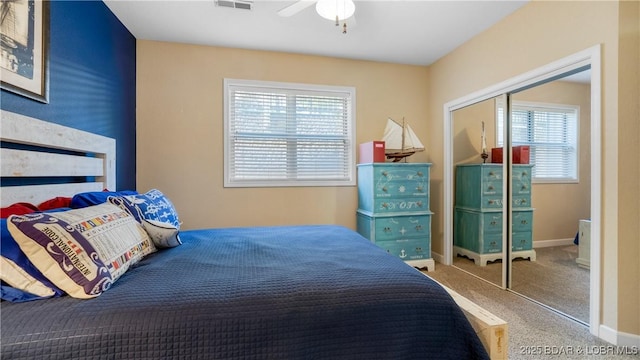 bedroom with multiple windows, carpet flooring, a closet, and ceiling fan