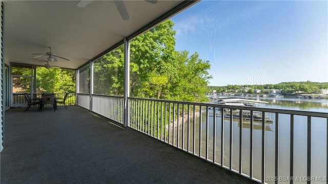balcony featuring ceiling fan and a water view