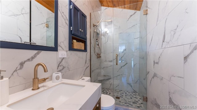 full bath with a shower stall, tile walls, toilet, and vanity