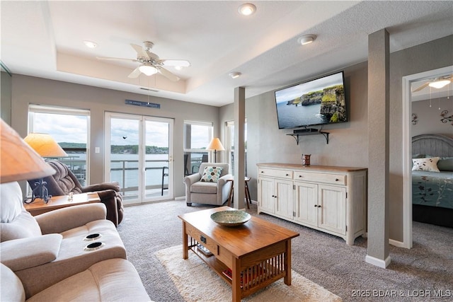 214 Emerald Bay Dr Unit 1D, Lake Ozark, MO 65049 - living room with ceiling fan, light carpet, and a raised ceiling