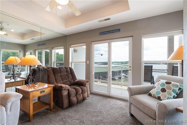 214 Emerald Bay Dr Unit 1D, Lake Ozark, MO 65049 - carpeted living room with a raised ceiling and ceiling fan