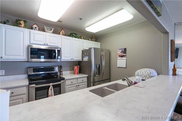 214 Emerald Bay Dr Unit 1D, Lake Ozark, MO 65049 - kitchen with appliances with stainless steel finishes, light countertops, white cabinetry, and a textured ceiling
