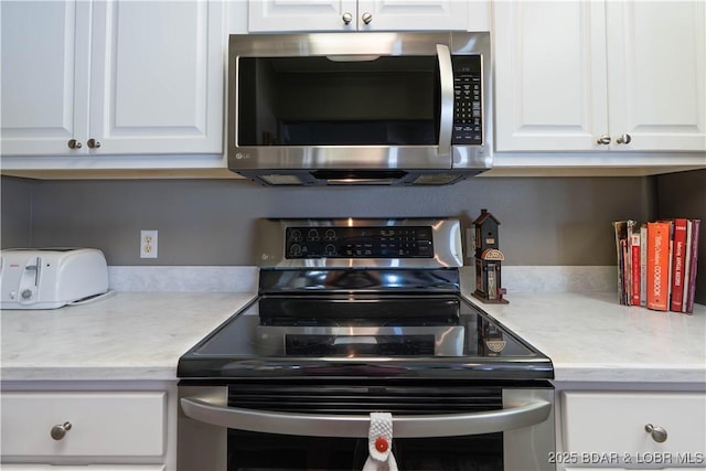 214 Emerald Bay Dr Unit 1D, Lake Ozark, MO 65049 - kitchen featuring stainless steel appliances, white cabinets, and light countertops